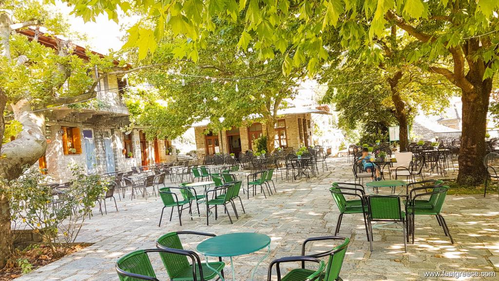 The village square (plateia) with tables of a cafe