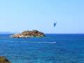 Surfer passes by the small islet of Panagia