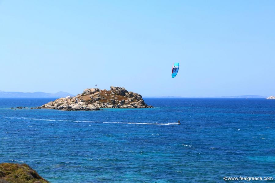 Surfer passes by the small islet of Panagia