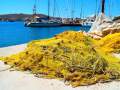 Piles of yellow fishing nets drying at the sun