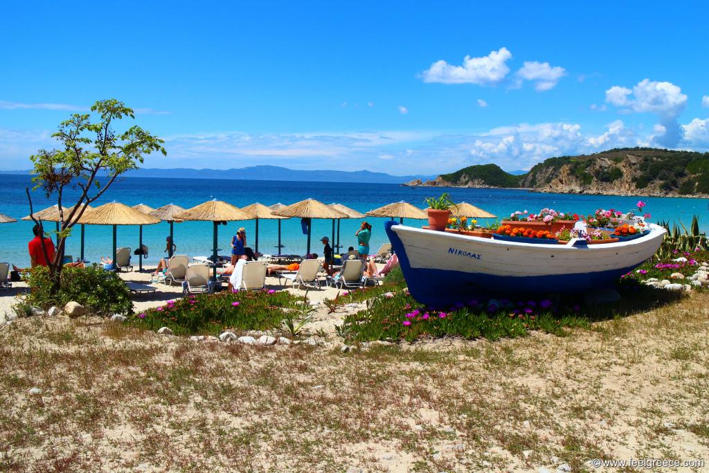 Boat with flowers at the background of blue sea and parasols