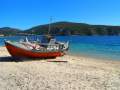 fishing boat rests on the sandy beach